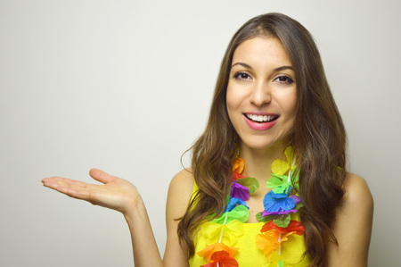 Attractive cheerful girl ready for carnival party showing your product or text on white background. Copy space.の写真素材