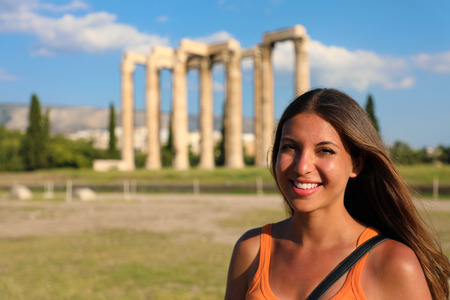 Smiling woman with the greek temple of Olympian Zeus on the background, Athens, Greeceの写真素材