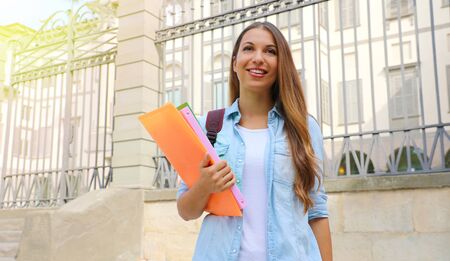 Happy student girl looking in front of her outdoors. Copy space.の写真素材