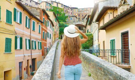 Discovering Italy. Back view of young attractive woman walking in old Italian city.の写真素材