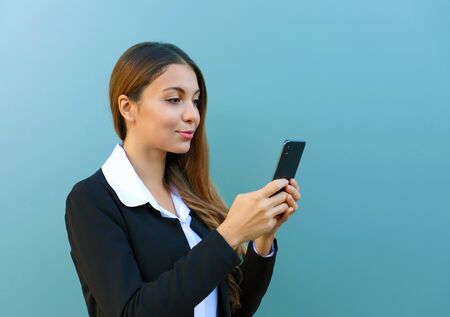 Portrait of beautiful young business woman chatting with smart phone outdoors.の写真素材