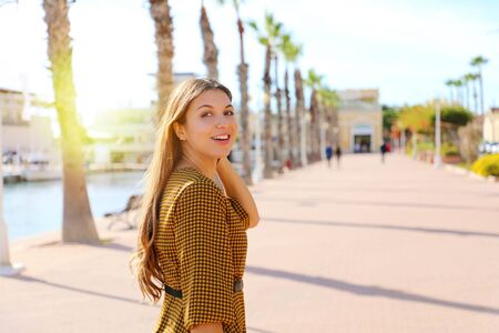 Fashion woman walking in Alicante promenade, Spain. Young woman enjoying walk in Mediterranean seaside city.の写真素材