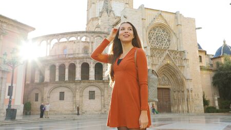 Portrait of beautiful tourist woman in Valencia with Cathedral on the background. Panoramic view of traveler girl with Valencia landmark in Spain.の写真素材