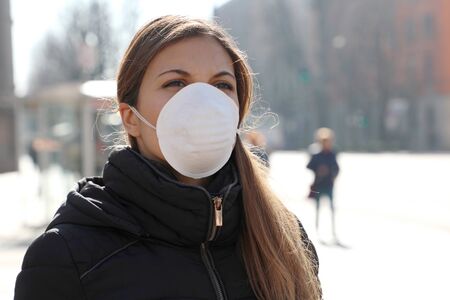 COVID-19 Woman wearing face mask protective for spreading of flu disease virus, protection against influenza viruses and diseases. Girl with surgical mask on face against Coronavirus Disease 2019 in city street.の写真素材