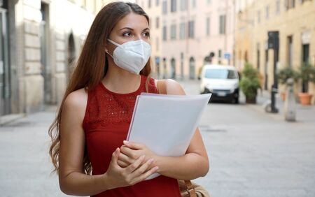 COVID-19 Global Economic Crisis Unemployed Worried Girl with KN95 FFP2 Mask  Looking for Job Walking in City Street Delivering Curriculum Vitaeの写真素材