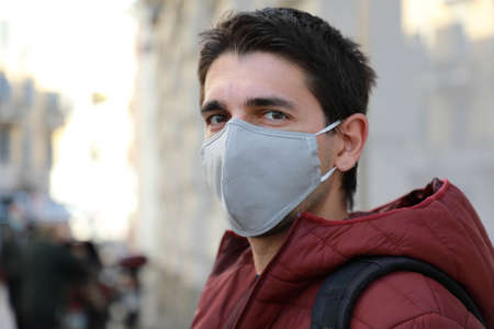 Close up of man in protective mask outdoors. Young man stands in street and looking at camera.の写真素材
