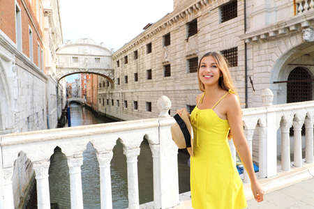 Happy young woman on Venice Bridge of Sighs. Beautiful girl looking to the side on Venice bridge, Italy.の写真素材