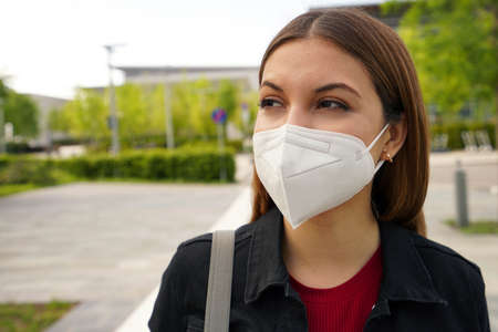 FFP2 protective mask. Close up of young woman wearing medical face mask in street as prevention and protection.の写真素材