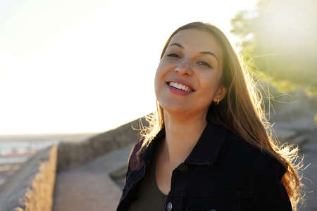 Young brazilian woman smiling at sunset