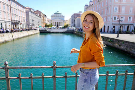 Traveler girl standing on the bridge with beautiful view of Trieste city, Italyの写真素材