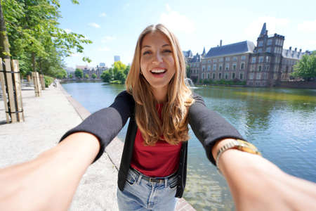 Selfie of young woman with the complex of buildings Binnenhof on Hofvijver in The Hague, Netherlandsの写真素材