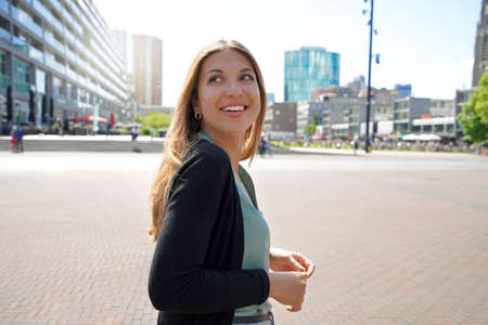 Portrait of beautiful multi ethnic woman walking in Rotterdam city with modern architecture in...