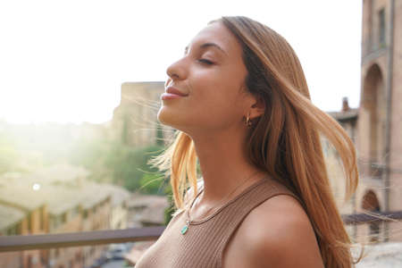 Profile of woman breathe relaxed with closed eyes on sunset. Beauty sunshine girl side portrait. Positive emotion life success mind peace concept.の写真素材