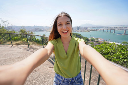 Self portrait of Brazilian woman with the Terceira Ponte bridge that unites the city of Vila Velha to Vitoria in Espirito Santo State, Brazilの写真素材