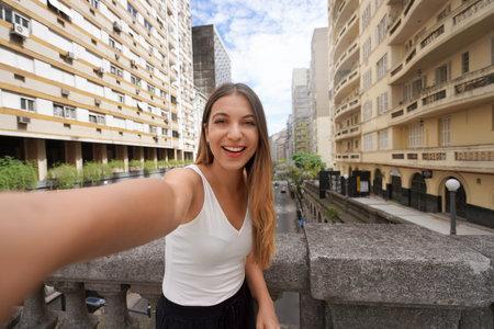 Beautiful smiling girl takes self portrait on Otavio Rocha Viaduct landmark in the city of Porto...