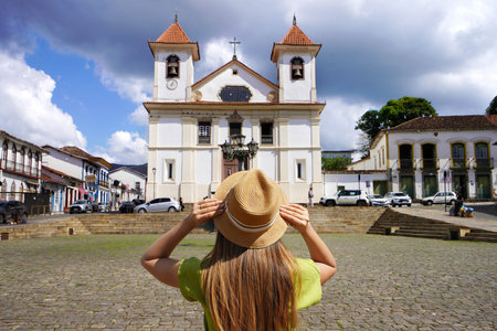 Tourism in Mariana, Brazil. Back view of young tourist woman in Mariana Cathedral square in Minas Gerais, Brazil.の写真素材