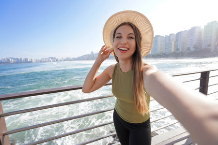 Brazilian girl takes self portrait on Guaruja promenade in Brazil, South Americaの写真素材