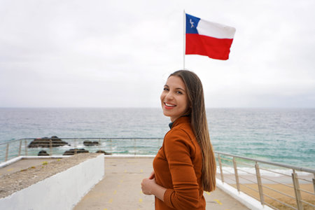 Portrait of young woman on Vina del Mar seafront with Chilean flag on the background, Valparaiso, Chileの写真素材