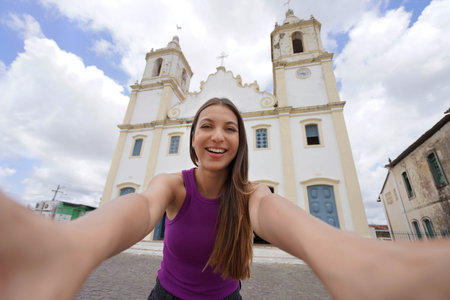 Self portrait of beautiful young woman in front of the facade of Parish Church of Our Lady of Victory, Sao Cristovao, Sergipe, Brazilの写真素材