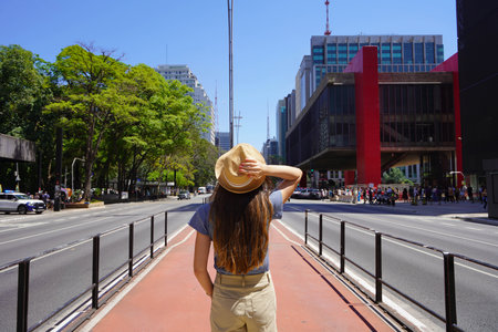 Tourism in Sao Paulo City, Brazil. Woman with a hat from behind on Paulista Avenue, Sao Paulo,...