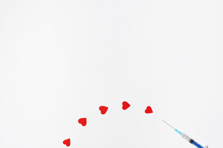 Safe vaccination concept. Syringe like injecting hearts on a white background, copy space.
