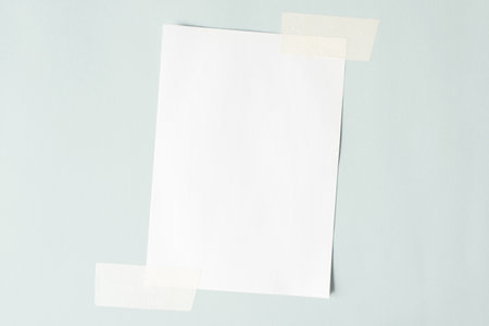 One sheet of paper crookedly pasted on the wall. White sheet mock up, copy space.の写真素材