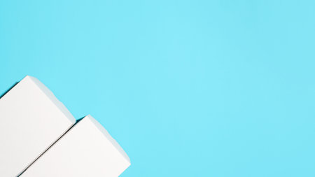 Two white closed boxes on a blue background, flat lay. Layout, empty space for text.の写真素材
