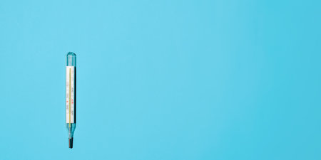 Classic Celsius thermometer on a light blue background, flat lay. Banner, space for text on the right. medical minimalist photoの写真素材