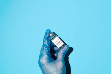 Vaccine production concept, global immunization of the population. Hand in medical gloves holding a...