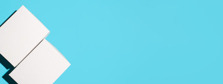 Two closed white boxes on a blue background, top view. Mockup banner, copy space.の写真素材