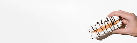 Hand holding meringue cake on a white background, copy space. sweet banner top viewの写真素材