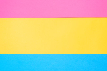 Three color linear geometry, copy space. Multicolor paper background. Yellow pink and blue geometric backdrop.の写真素材