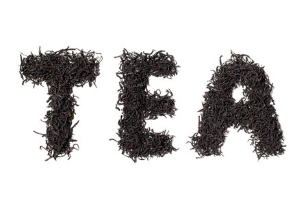 Word Tea made from dry tea leaves. Ceylon tea leaves isolated on white background, top view.の写真素材