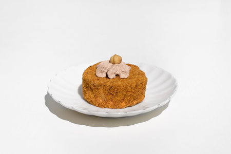 Cake decorated with cream and nuts, white table background. Morning breakfast with dessert in the kitchen.の写真素材
