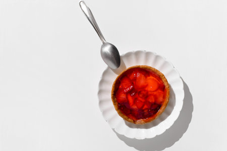 Cheesecake with strawberries on plate, white table background. Morning breakfast in the kitchen. Food banner, top view, copy space.の写真素材