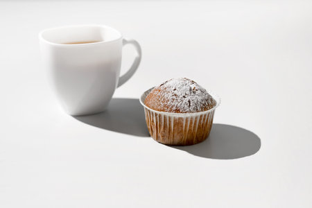 Morning breakfast with cupcake. Cup of tea and muffin on a white table.の写真素材
