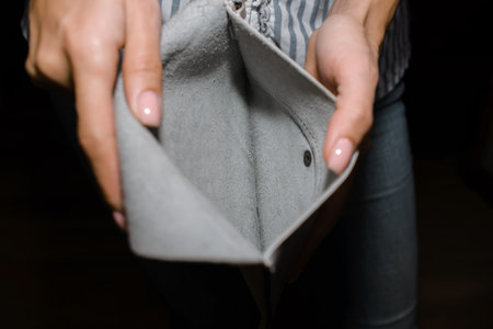 Woman shows empty wallet, close-up. The concept of bankruptcy, income decline, poverty,...