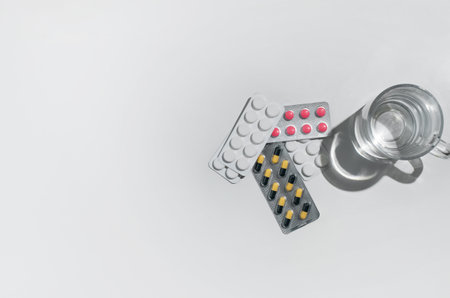 Pharmaceutical tablets of different colors and a glass of water. treatment concept, medications....