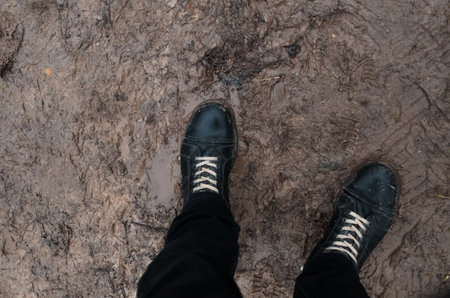 Boots standing in mud and slush, pov. Concept bad weather, off-road, thawの写真素材