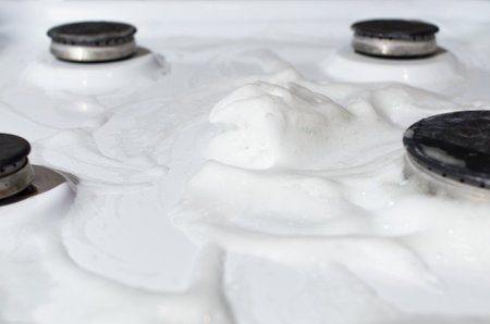 Gas stove surface with foam cleaning chemical. Household hygiene concept.の写真素材