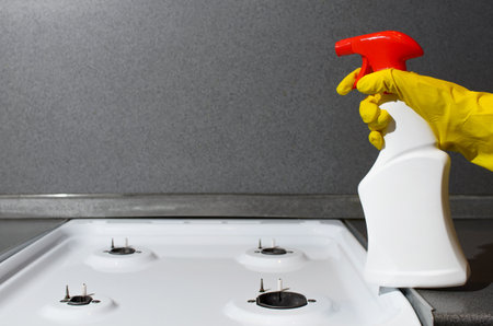 Woman's hand in a rubber glove splashing with a chemical spray, copy space Hygienic house cleaningの写真素材