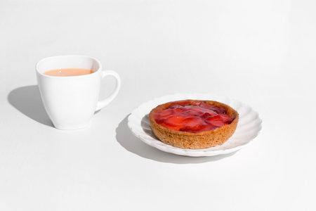 Morning breakfast with berry cheesecake. Cup of tea and fruit cheesecake on a white table.の写真素材