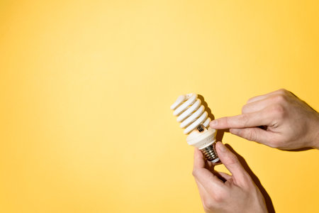 Male hands holding a burnt out light bulb. Hand showing the place of burnout. top view, copy spaceの写真素材