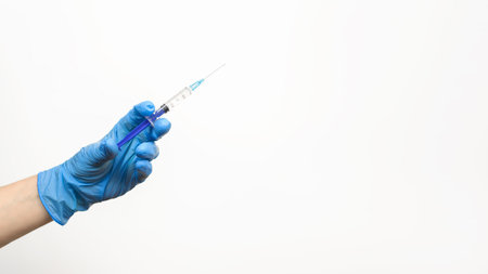 Hand nurse in medical glove holding syringe with an injection on white background, copy space. vaccination conceptの写真素材