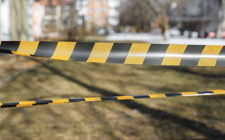 Orange and black tapes of outdoor area fencing. Close up, selective focusの写真素材