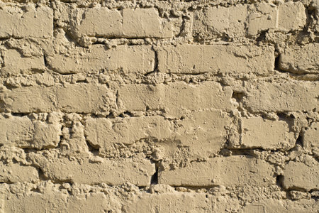 Textured rough wall of yellow bricks outside. Uneven masonryの写真素材