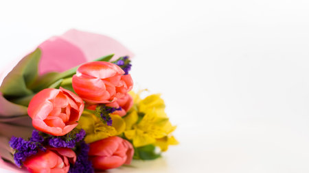 Decorated bouquet of flowers lying on a white background, copy space. Selective focus focus. Bunch of tulips and liliesの写真素材