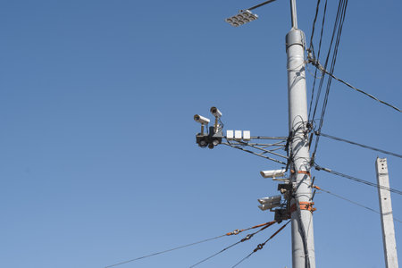 Video camera on a pole outside against a clear blue sky. Tracking system for citizens, face recognitionの写真素材