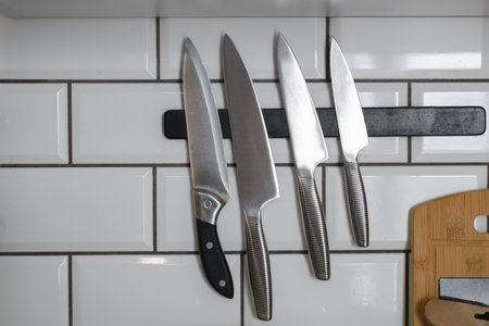 Set of knives and a magnetic holder in the kitchen.の写真素材