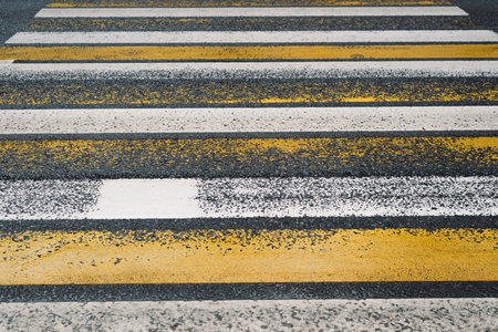 Crosswalk. White and yellow stripes road markings on a rainy dayの写真素材